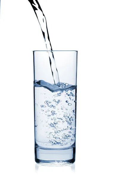 Woda jest wlewana do szklanki. — Zdjęcie stockowe