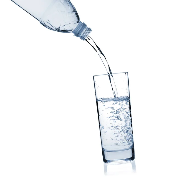 Vatten hälls i ett glas från en bott — Stockfoto