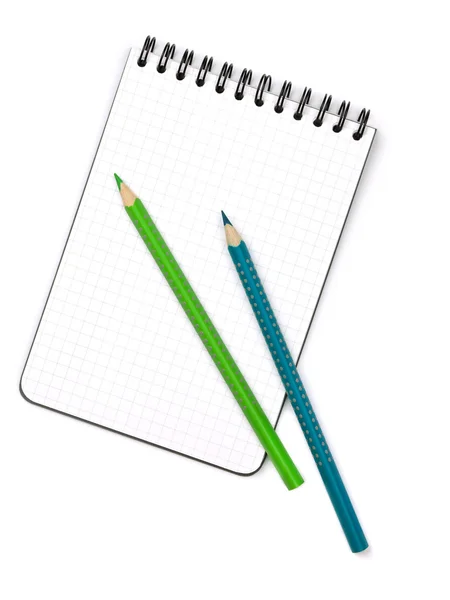 Dvě barevné tužky na poznámkovém bloku — Stock fotografie