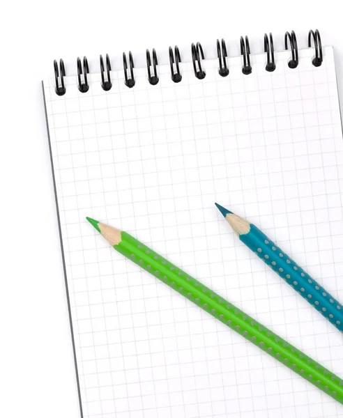 Dvě barevné tužky na poznámkovém bloku — Stock fotografie