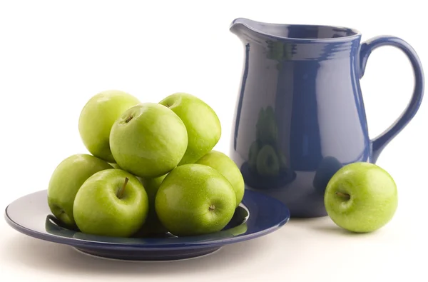 Green apples and blue pitcher — Stock Photo, Image