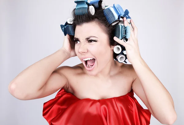 Menina emocional com encrespadores de cabelo na cabeça — Fotografia de Stock