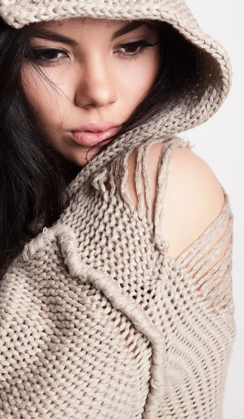 Krásná mladá brunetka v vlněný svetr představují na šedé bac — Stock fotografie
