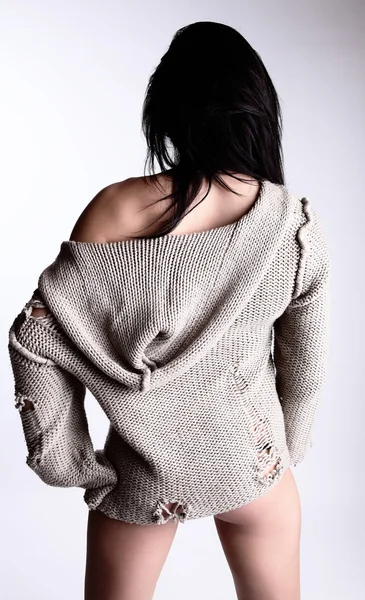 Bella giovane bruna in un maglione di lana posa su un bac grigio — Foto Stock