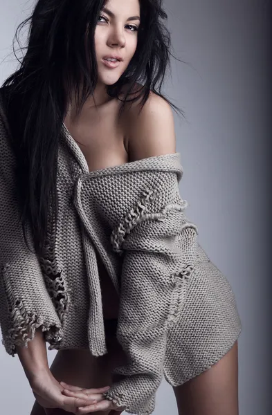 Hermosa joven morena en una pose suéter de lana en un bac gris —  Fotos de Stock