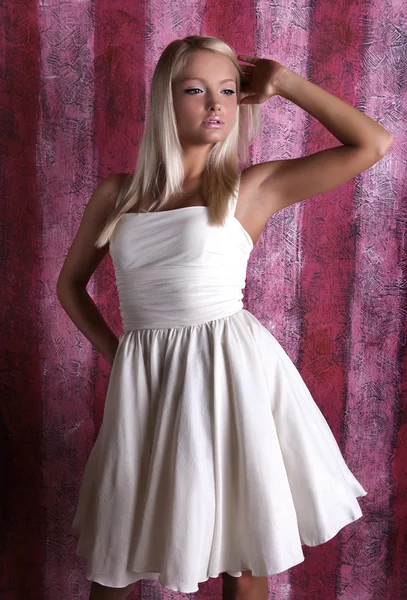 Menina atraente em vestido branco em um fundo rosa — Fotografia de Stock