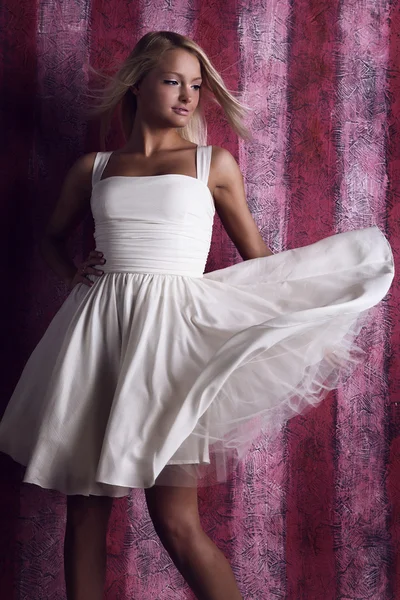 有吸引力的女孩在粉红色的背景上的白色礼服 — 图库照片