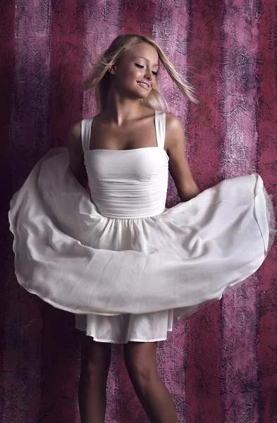 Chica atractiva en vestido blanco sobre un fondo rosa — Foto de Stock