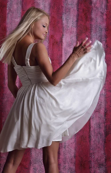 Attraktive Mädchen in weißem Kleid auf rosa Hintergrund — Stockfoto