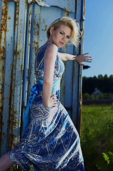 Elegant dam i en? ocktail klänning mot gamla rostiga behållare — Stockfoto