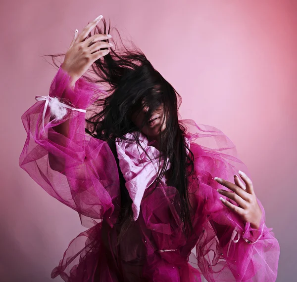Mulher dançando em fundo rosa — Fotografia de Stock
