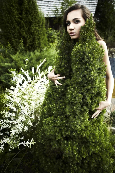 The girl in a dress from a decorative fur-tree. — Stock Photo, Image