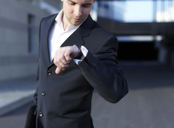 Ein gutaussehender Geschäftsmann schaut auf die Uhr — Stockfoto