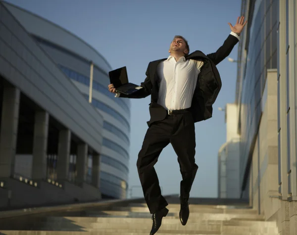 Saltando empresário sobre fundo urbano — Fotografia de Stock