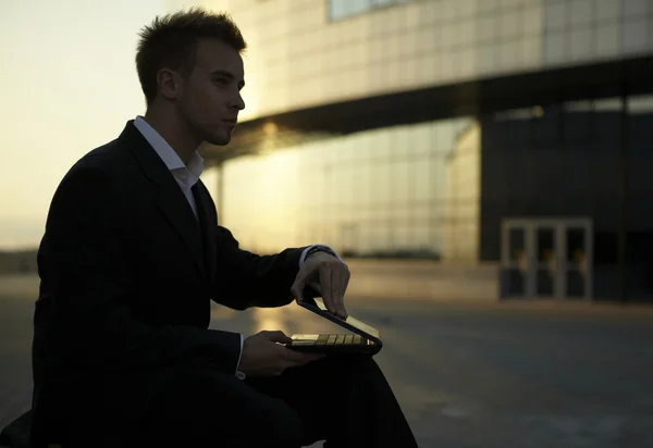 Affärsman med laptop på en solnedgång — Stockfoto