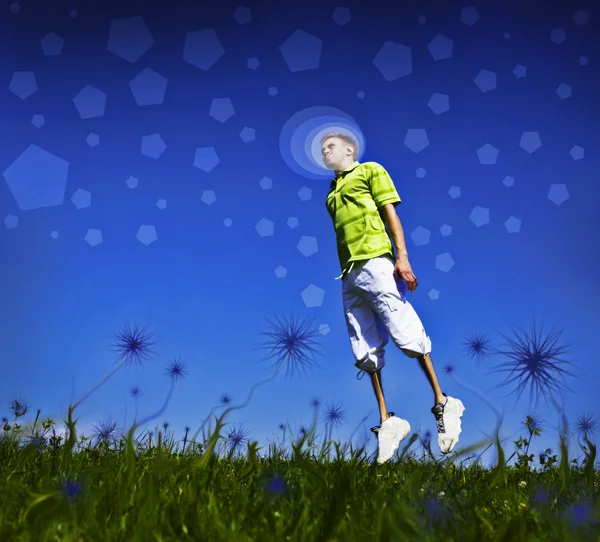 Saltando chico en una camisa verde contra el cielo azul . — Foto de Stock