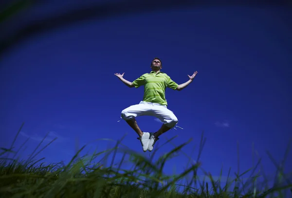 Mavi gökyüzü Yeşil gömlekli adam yukarı Zıplama. — Stok fotoğraf