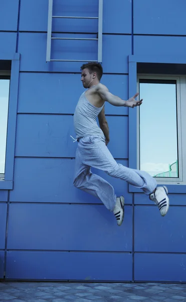 Jonge straat acrobat maakt een moeilijke sprong — Stockfoto