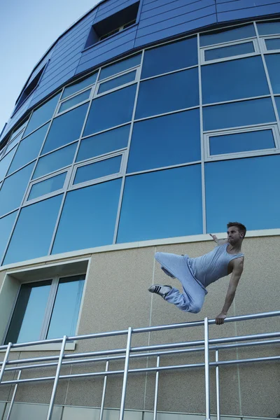 Jonge straat acrobat maakt een moeilijke sprong — Stockfoto