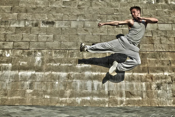都市の背景に踊る若い魅力的な男 — ストック写真
