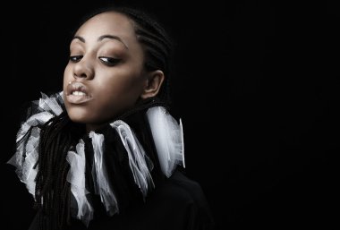 Attractive afro-american beauty in a black-white theatrical jabot. Close-up clipart