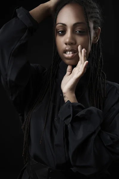 Портрет красивой молодой черной женщины, позирующей на черном фоне . — стоковое фото