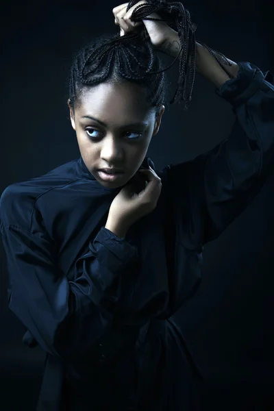 Porträt einer schönen jungen schwarzen Frau, die vor schwarzem Hintergrund posiert. — Stockfoto