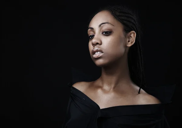 Porträt einer schönen jungen schwarzen Frau, die vor schwarzem Hintergrund posiert. — Stockfoto