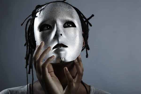 Sombere vrouw in zilveren masker poseren op een zwarte achtergrond. — Stockfoto