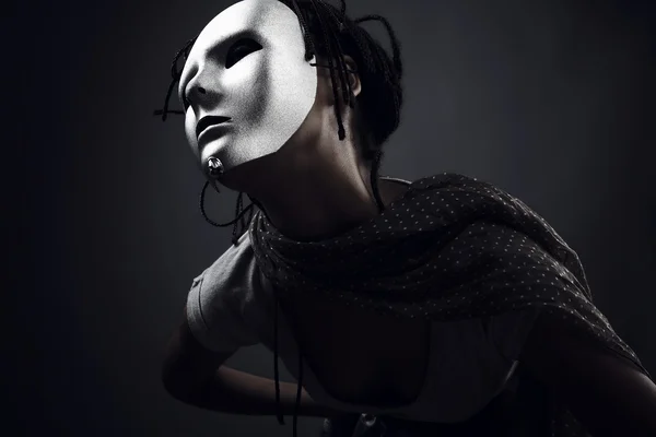 Komor nő pózol a fekete háttér, ezüst maszk. — Stock Fotó