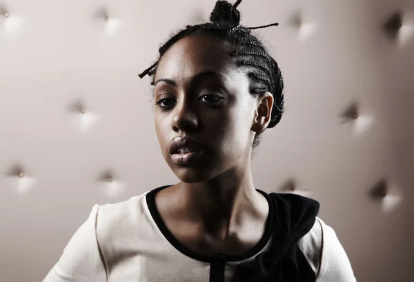 ベージュ レザーを上の美しいアフリカ女性ポーズのクローズ アップの肖像画 — ストック写真