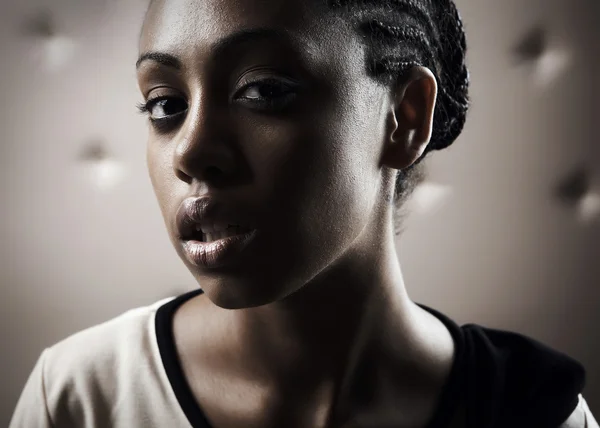 Nahaufnahme Porträt einer schönen Afrikanerin, die auf einem beigen Lederrücken posiert — Stockfoto
