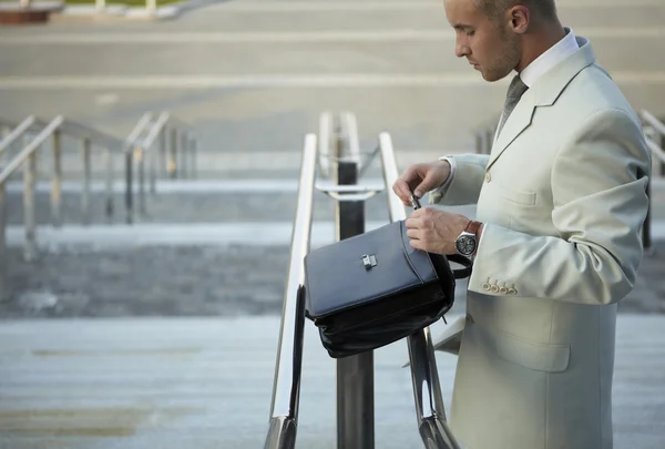 Business man holding elegant black leather briefcase. — Stock Photo, Image