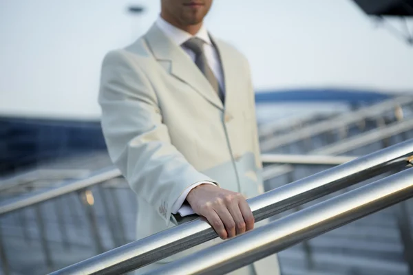 Mão de homem em um terno clássico guarda para um corrimão — Fotografia de Stock