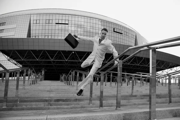 Молодой бизнесмен с портфелем бегает по лестнице — стоковое фото