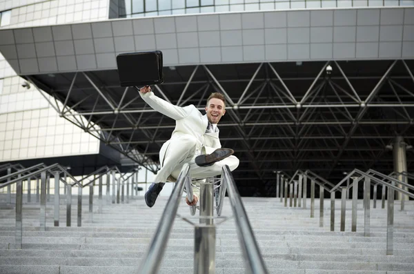 Jonge zakenman met aktetas uitgevoerd op trap — Stockfoto
