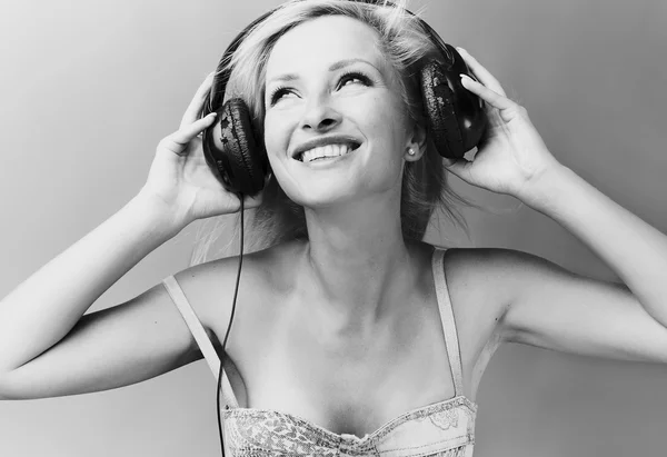 Sexig blond modell lyssnar på musik. — Stockfoto