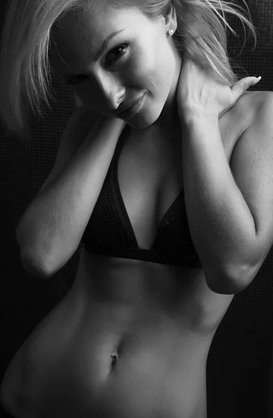 Bonito jovem mulher em lingerie posando em um fundo escuro — Fotografia de Stock