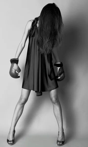 Sexy brunette in bokshandschoenen poseren gekleed in zijden jurk. — Stockfoto