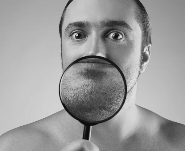 Funny portrait of a adult man with a magnifying glass. — Stock Photo, Image