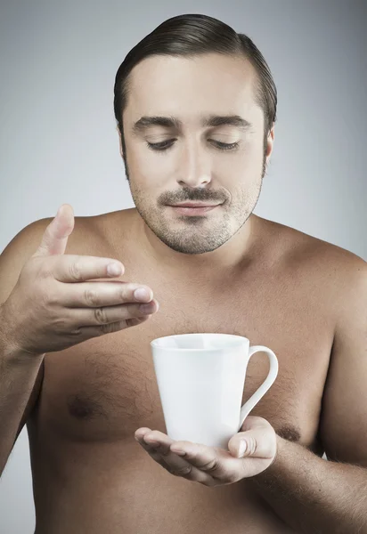 Feliz joven caucásico chico teniendo una taza de café aislado en gris backgroun — Foto de Stock