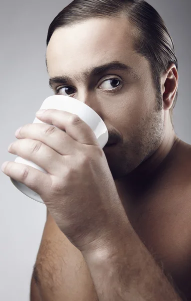 Heureux jeune homme caucasien ayant une tasse de café isolé sur fond gris — Photo
