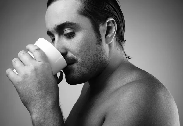 회색 backgroun에 고립 된 커피 한 잔 마시고 행복 한 젊은 백인 남자 — 스톡 사진