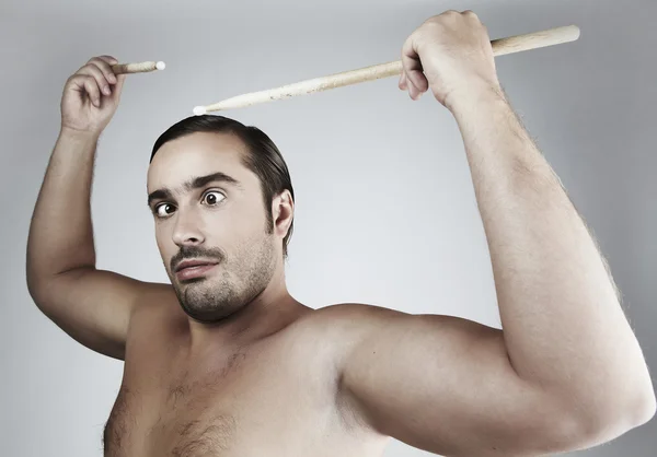 Portrait of funny man Beating drum-type sticks on his head. — Stock Photo, Image
