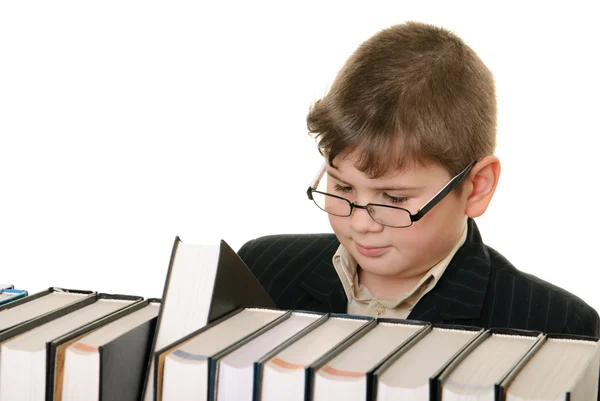 Pojke väljer uppmärksamt bok — Stockfoto