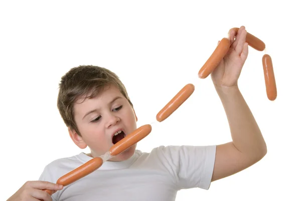 Rapaz faminto morde salsicha — Fotografia de Stock