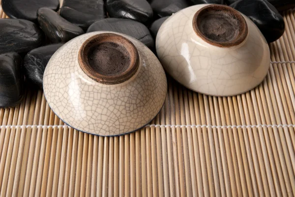 Две перевернутые чашки для чая лежат на камнях — стоковое фото