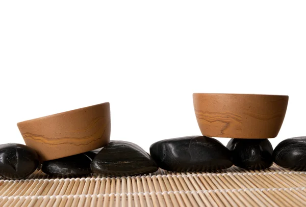 Due tazze di argilla, stuoia e pietre — Foto Stock