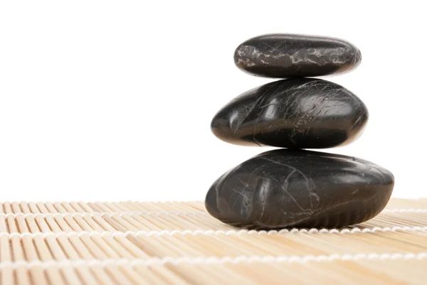 Algunas piedras oscuras yacen sobre una alfombra aislada — Foto de Stock