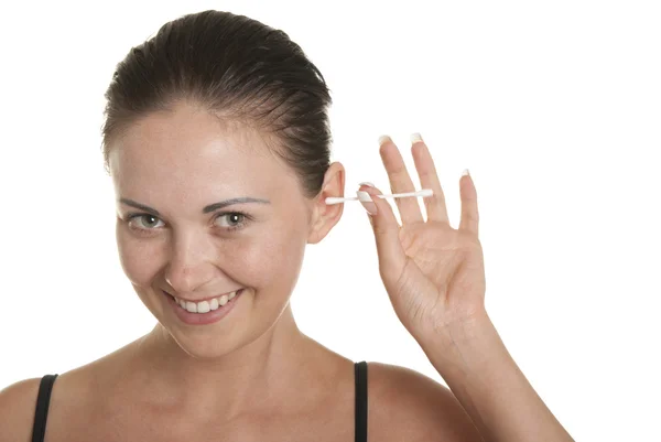 Улыбающаяся женщина чистит уши хлопчатобумажными бутонами — стоковое фото